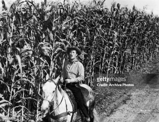 American actor Gordon MacRae as Curly in the musical 'Oklahoma!', 1955. Here he rides through a cornfield singing 'Oh What a Beautiful Mornin''.