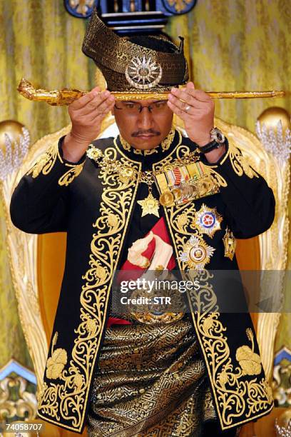 Kuala Lumpur, MALAYSIA: The thirteenth King of Malaysia, Sultan Mizan Zainal Abidin, lifts a ceremonial "keris" during his coronation at the National...