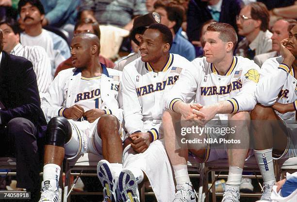 Tim Hardaway, Mitch Richmond and Chris Mullin of the Golden State Warriors sit on the bench during a game played in 1989 at the Oakland-Alameda...