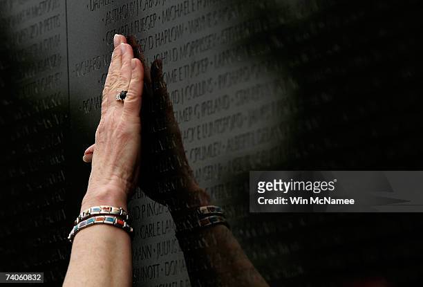 Ann Pruett reaches to touch the name of her husband, Richard Monroe Pruett, which was added to the Vietnam Veterans Memorial May 3, 2007 in...