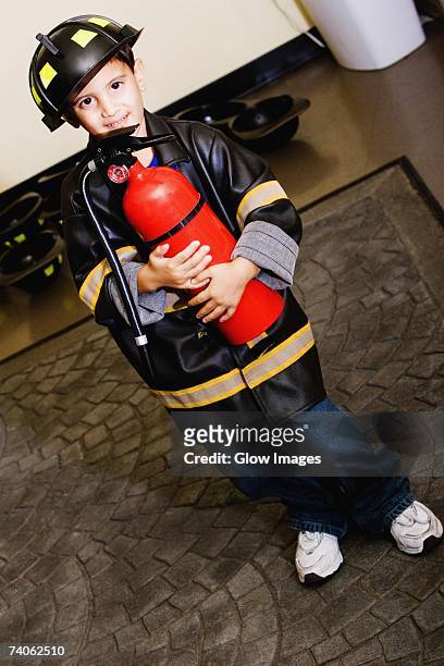 portrait of a boy standing in a fireman costume - boy fireman costume stock pictures, royalty-free photos & images