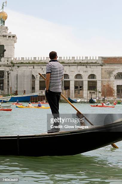 side profile of a gondolier standing on a gondola, venice, veneto, italy - gondolier stock pictures, royalty-free photos & images