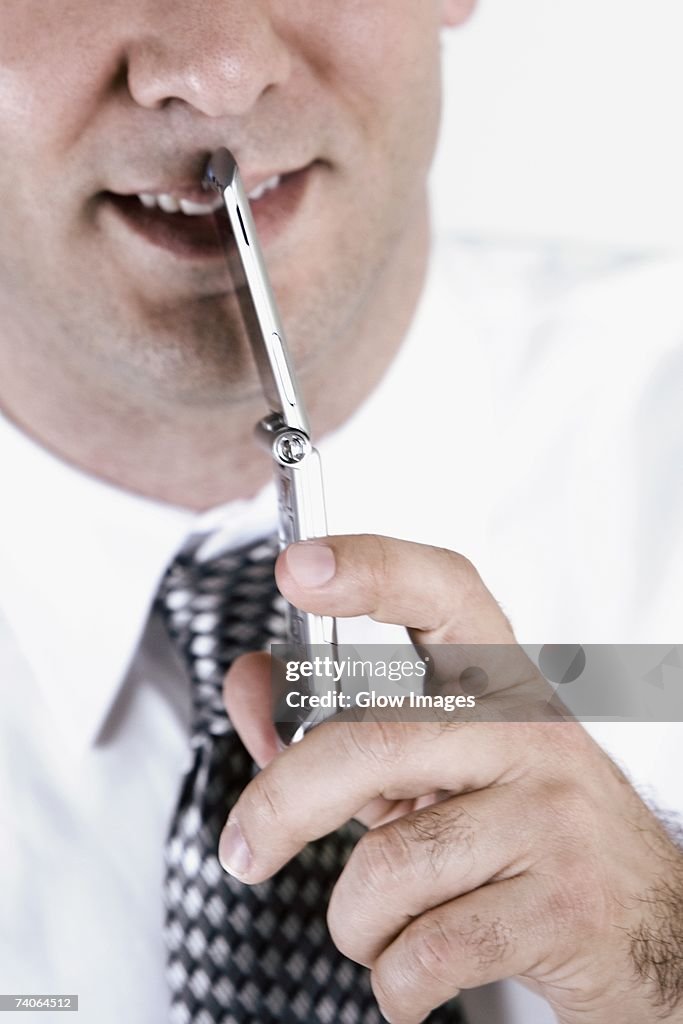 Close-up of a businessman holding a mobile phone and smiling