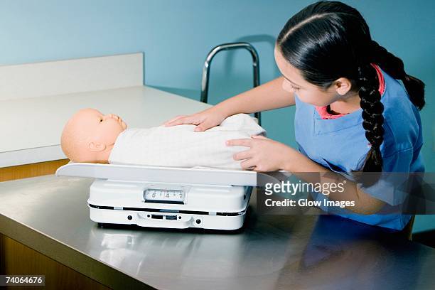 girl weighing a doll on a weighing scale - one baby girl only bildbanksfoton och bilder