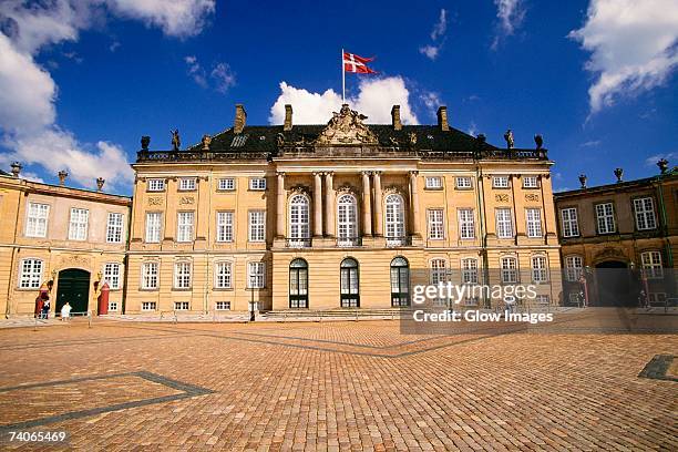 facade of a palace, amalienborg palace, copenhagen, denmark - danish flags stock pictures, royalty-free photos & images