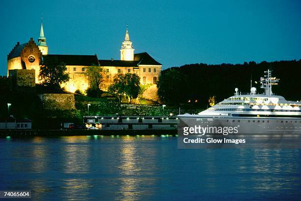 castle lit up at night, akershus fortress, oslo, norway - akershus fortress stock-fotos und bilder