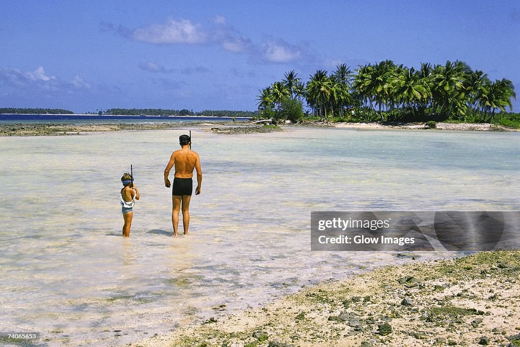 Man and a child standing on the beach, Majuro, Marshall Islands