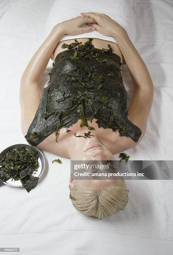 Young woman receiving seaweed treatment