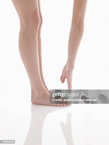 woman touching her toes (low section) - low section stock pictures, royalty-free photos & images