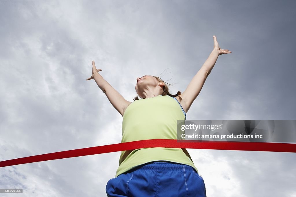 Female runner crossing finishing line (low angle view)