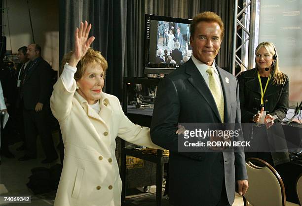 Simi Valley, UNITED STATES: California Governor Arnold Schwarzenegger escorts former US First Lady Nancy Reagan into the Air Force One Pavilion to...