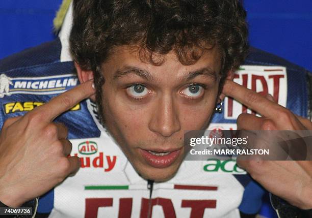 Italian MotoGP rider Valentino Rossi from the Yamaha Team, puts his earplugs in before leaving the pits during the second free practice session of...