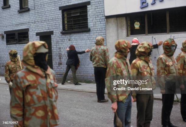 Masked members of the loyalist paramilitary organization, the Ulster Defence Association , detaining two hooded IRA suspects, Belfast, Northern...