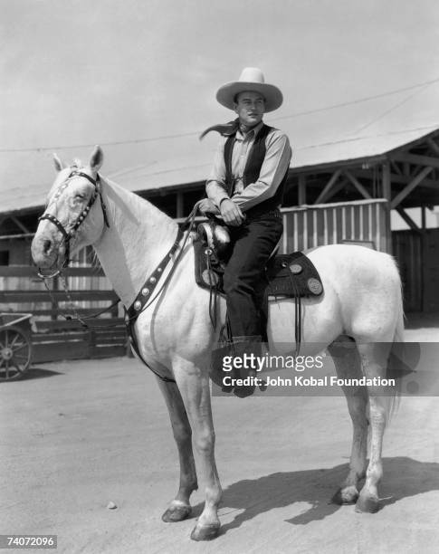 American actor John Wayne on horseback, circa 1935.