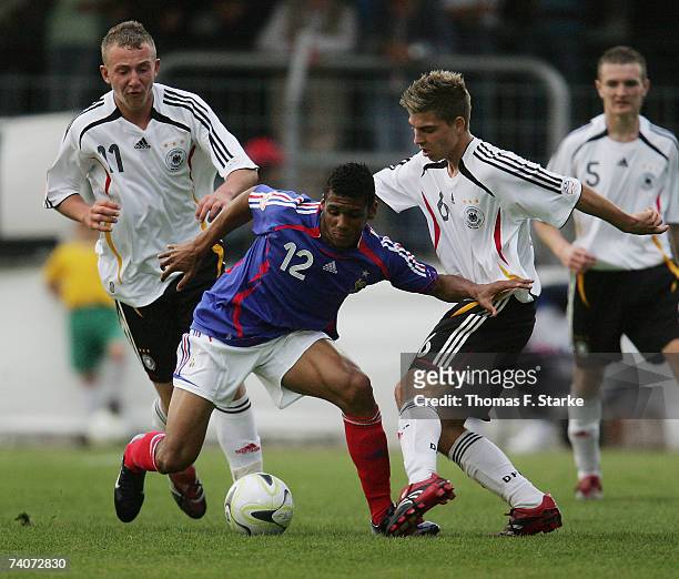 Marvin Knoll and Kevin Wolze of Germany tackle Yann M?Vila of France during the 2007 UEFA European Under 17 Championship group A match between France...