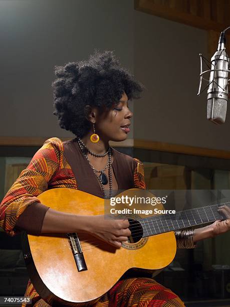 mujer tocando la guitarra - músico fotografías e imágenes de stock