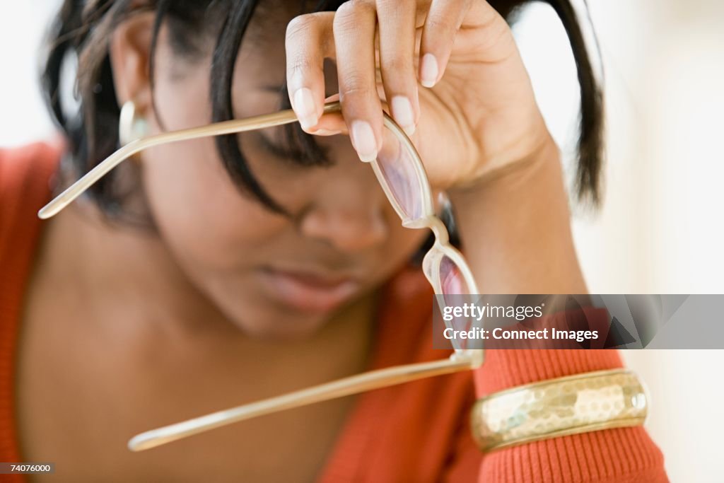 Woman removing her glasses