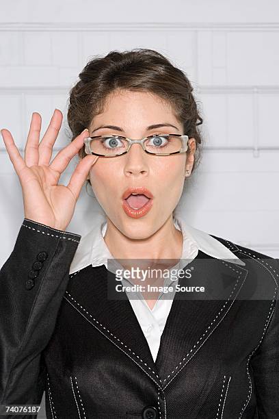 shocked young woman - hand adjusting stock pictures, royalty-free photos & images