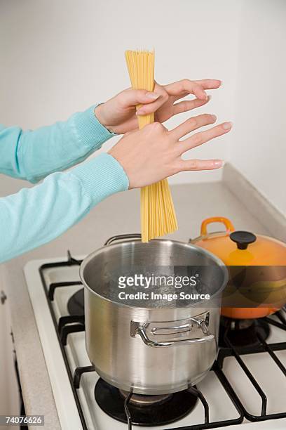 person cooking spaghetti - holding saucepan stock pictures, royalty-free photos & images