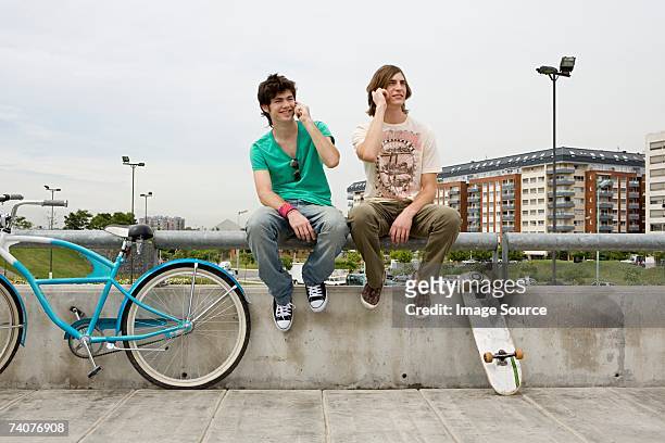 young men on cellphones - two boys talking fotografías e imágenes de stock