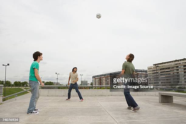 young men playing football - three storey stock pictures, royalty-free photos & images