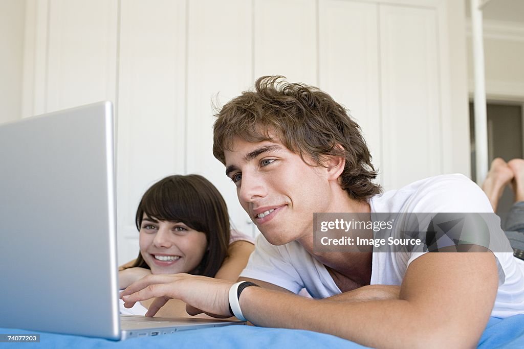 Teenage couple using laptop