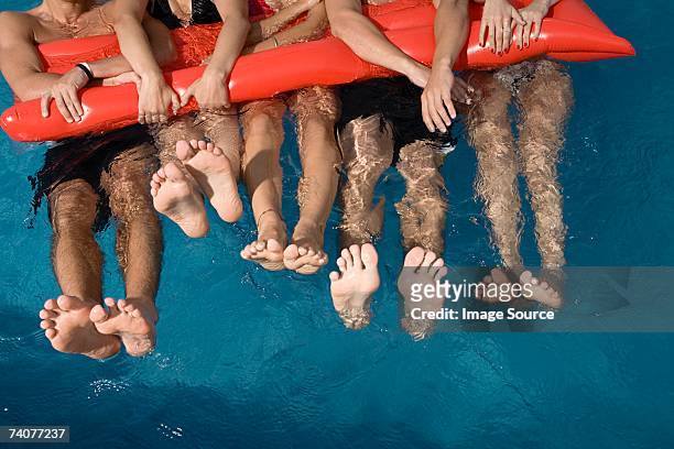 friends floating in swimming pool - teen boy barefoot stock pictures, royalty-free photos & images