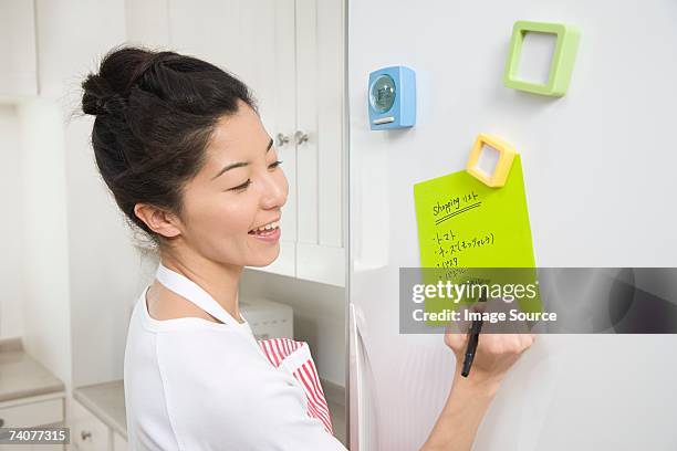 woman writing shopping list - shopping list stock pictures, royalty-free photos & images