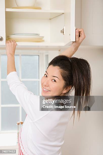 woman opening cupboard - cabinet door stock pictures, royalty-free photos & images