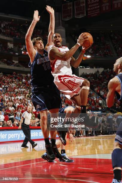 Tracy McGrady of the Houston Rockets goes up for a shot under pressure from Mehmet Okur of the Utah Jazz in Game Five of the Western Conference...