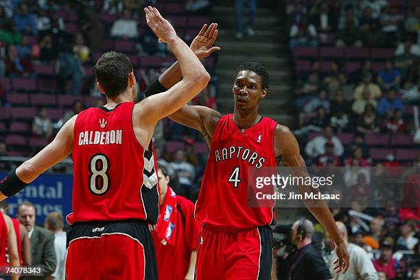 Chris Bosh and Jose Calderon of the Toronto Raptors high five during a break in play against the New Jersey Nets in Game Six of the Eastern...