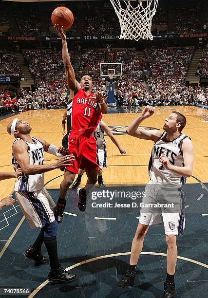 Ford of the Toronto Raptors shoots against Vince Carter and Bostian Nachbar of the New Jersey Nets in Game Six of the Eastern Conference...