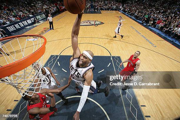 Vince Carter of the New Jersey Nets shoots against Chris Bosh of the Toronto Raptors in Game Six of the Eastern Conference Quarterfinals during the...