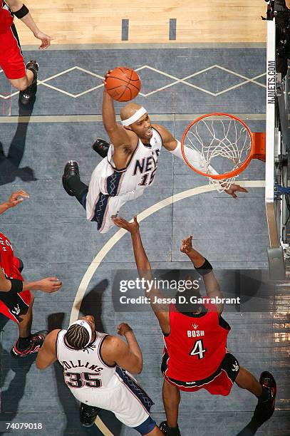 Vince Carter of the New Jersey Nets shoots against Chris Bosh of the Toronto Raptors in Game Six of the Eastern Conference Quarterfinals during the...