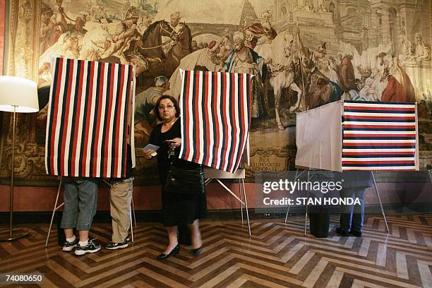 New York, UNITED STATES: A woman steps out of a booth after voting in the second round of the French presidential election 05 May 2007 at the French...