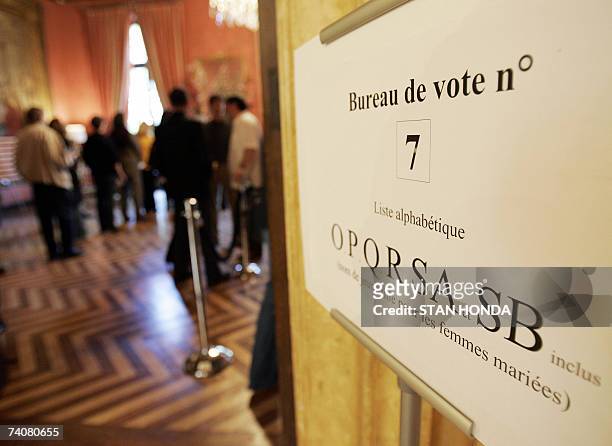 New York, UNITED STATES: A sign points to a polling place as people vote in the second round of the French presidential election 05 May 2007 at the...