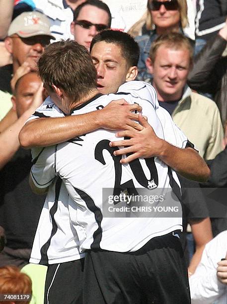 London, UNITED KINGDOM: Fulham's American midfielder Clint Dempsey embraces his compatriot Brian McBride 05 May 2007 after scoring his side's first...