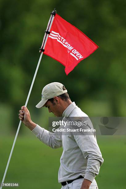 Martin Kaymer of Germany replaces the flag after making his putt on the ninth hole during the delayed second round of The Telecom Italian Open Golf...