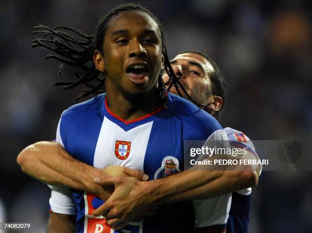 Porto's Brazilian Anderson Oliveira is hugged by teammates Lisandro Lopez , from Argentina, as he celebrates his opening goal against Nacional during...