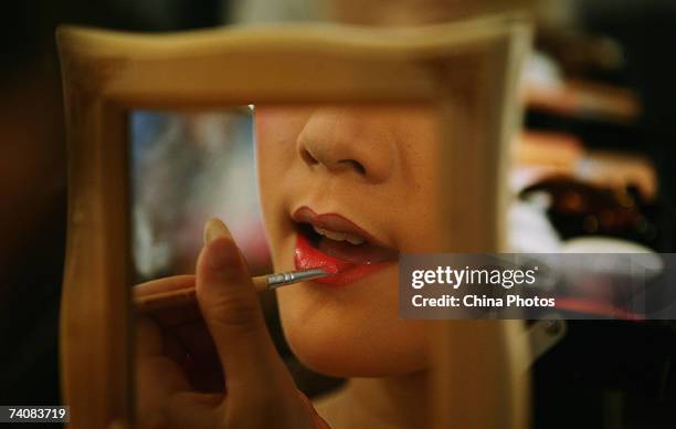 An actress in Yueju Opera puts on make-up before performance on May 5, 2007 in Wenzhou of Zhejiang Province, China. Yueju opera, also known as...