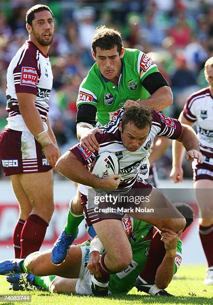 Glenn Stewart of Manly is tackled by Terry Campese of the Raiders during the round eight NRL match between the Canberra Raiders and the Manly...