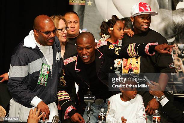 Floyd Mayweather Jr. Speaks to the press as his manager Leonard Ellerbe looks on while rapper 50 Cent holds Mayweather's daughter Iyanna behind...