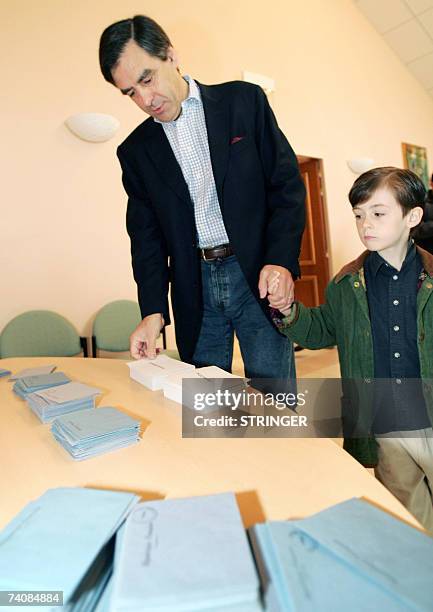 Former French minister and political advisor to Nicolas Sarkozy, Francois Fillon, next to his son Arnaud, picks up ballots before voting at a polling...