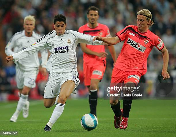 Cicinho of Real Madrid vies for the ball with Christian Poulsen of Sevilla during the Primera Liga match between Real Madrid and Sevilla on May 6,...