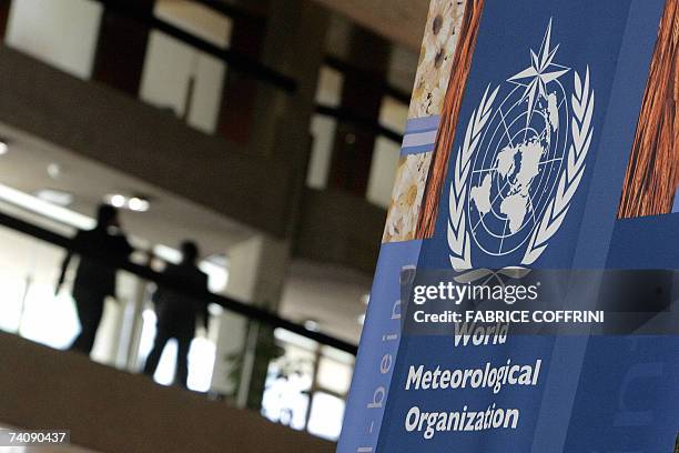 Delegates walks to the congress room behind a sign of the World Meteorological Organization 07 May 2007 in Geneva. The specialized agency of the...