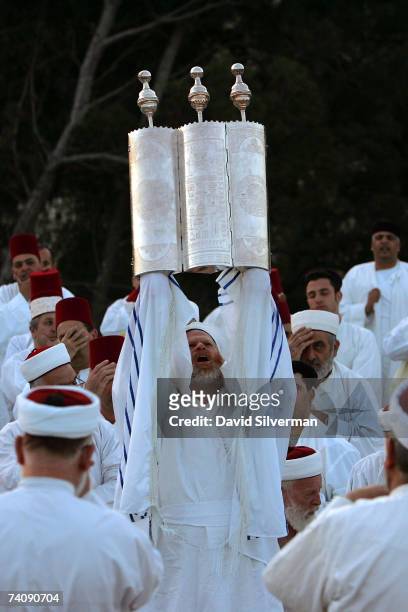 The High Priest of the ancient Samaritan sect holds aloft a silver-encased Torah scroll as the community holds prayers at dawn on the last day of...
