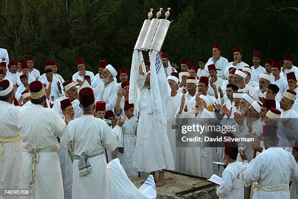 The High Priest of the ancient Samaritan sect holds aloft a silver-encased Torah scroll as the community holds prayers at dawn on the last day of...