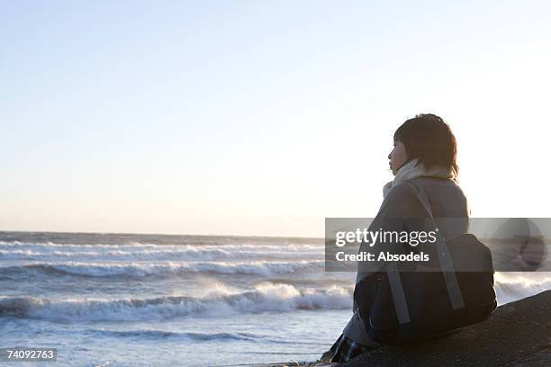 a girl looking at the sea - female looking away from camera serious thinking outside natural stock pictures, royalty-free photos & images