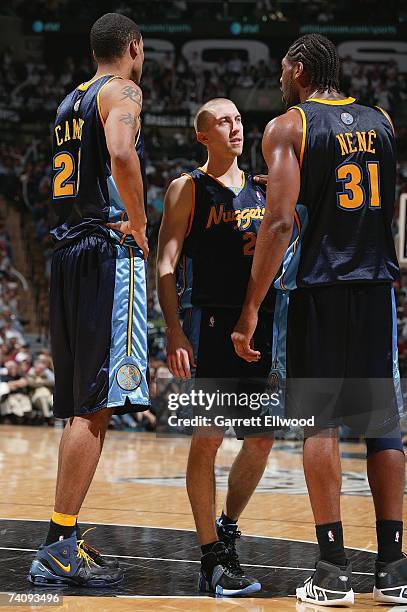 Marcus Camby, Steve Blake adn Nene of the Denver Nuggets talk on the court in Game Two of the Western Conference Quarterfinals against the San...