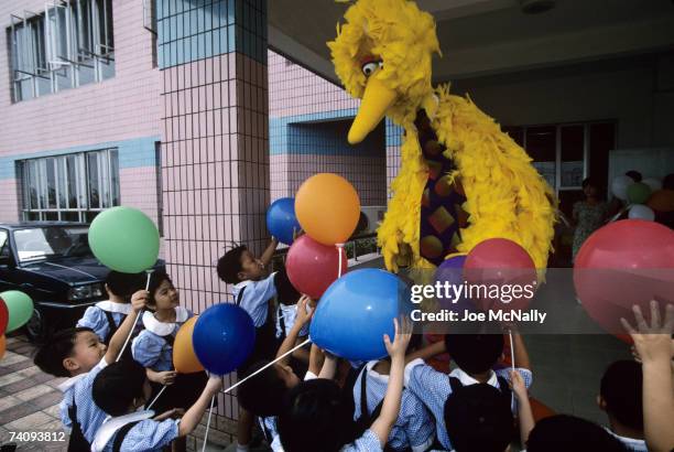 Big Bird of Sesame Street greets a group of young school children with balloons in October 1998 outside the entrance of a building in Shanghai.